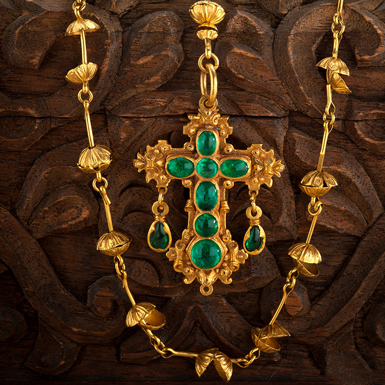 An emerald cross and gold rosary 